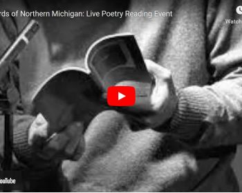 UPPAA A grayscale image of a person holding an open book, focusing on their hands and the book, with a youtube play button overlay, titled "the bards of northern michigan: live poetry reading event".
